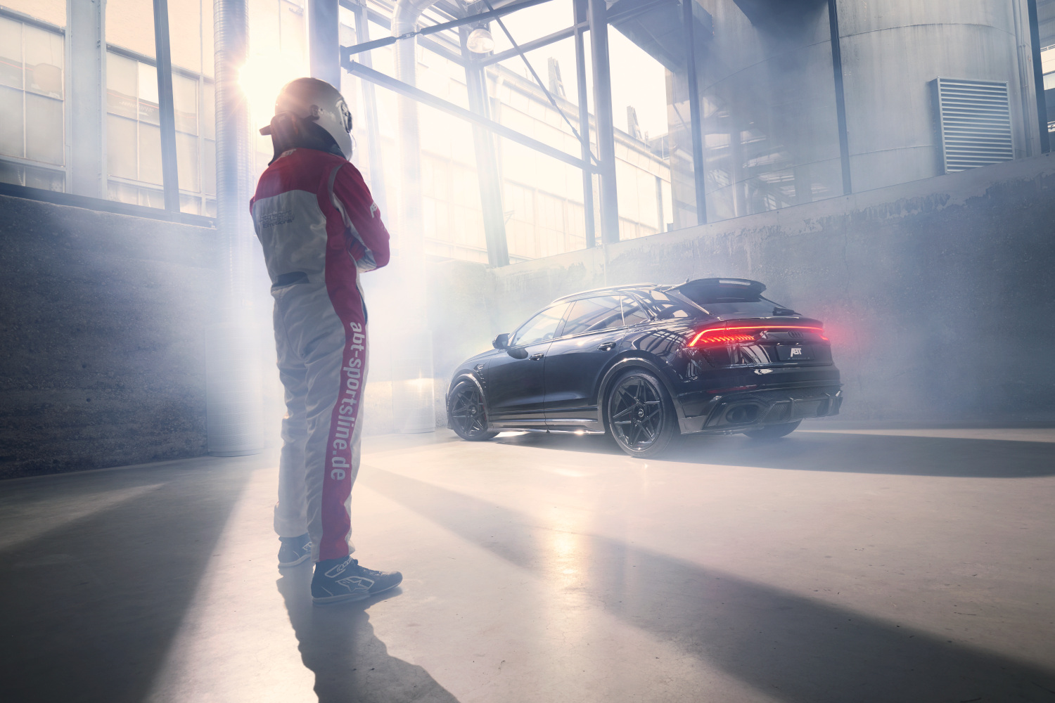 Racing driver looks at black RSQ8 Signature Edition in Hall